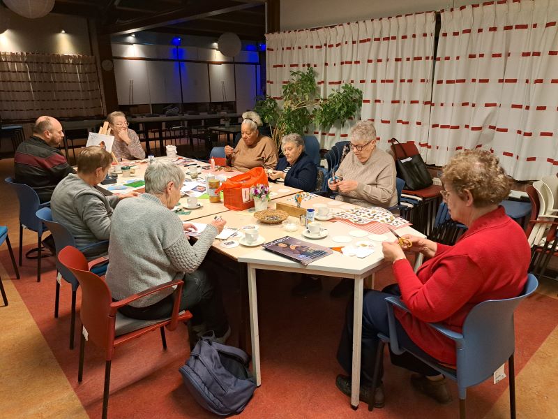 Volwassenen knutselen samen bij De Basis